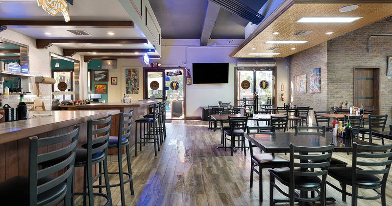 Food and bar counters with tall chairs, dining tables