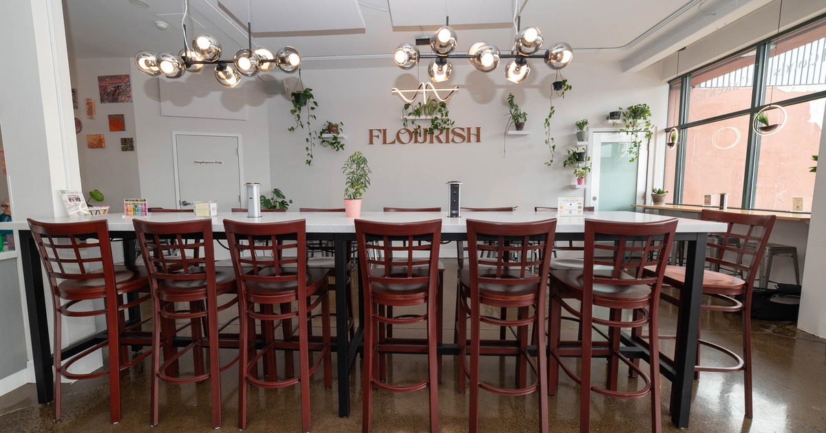 A modern room with a long table, high-backed chairs