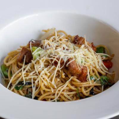 Pork Belly Pasta served in a white dish.