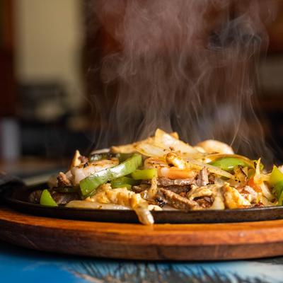 Mixed meat fajitas, with onion, tomato, peppers, rice, beans and guacamole