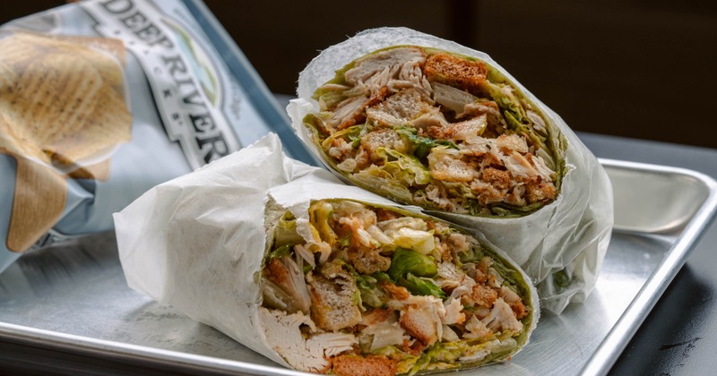 Chicken Caesar wrap served with a bag of chips