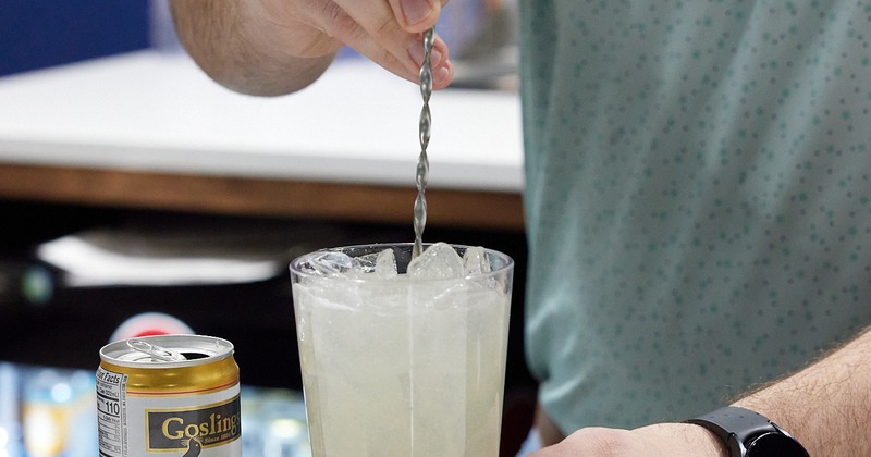 A cocktail being stirred with a bar spoon