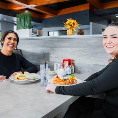 Two friends having breakfast at a restaurant table.