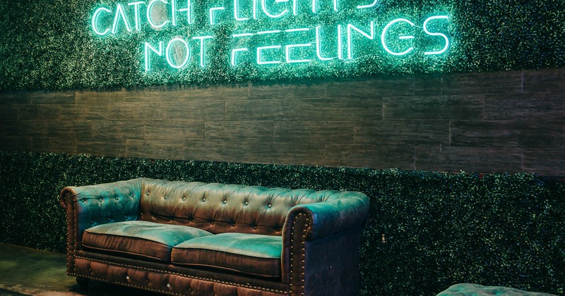 Interior, couch near wall with neon sign