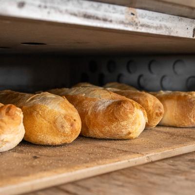Freshly baked bread on a wooden shelf.