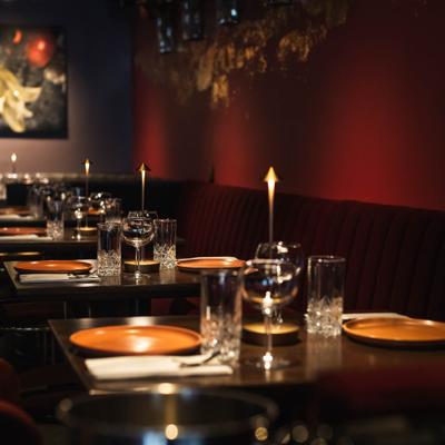 Interior with booth seating, chairs and tables set for dining.