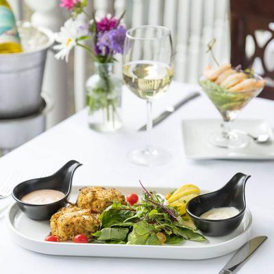 Crab cakes served with mixed greens, lemon wedges, and dipping sauces.