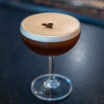 Rude Awakening cocktail glass on a dimly lit bar.