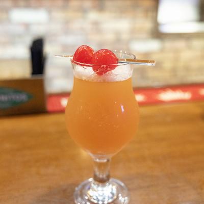 Pineapple Upside Down Martini garnished with two cherries on a pick.