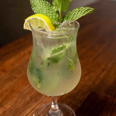 Mojito with lemon wedge and mint leaves.