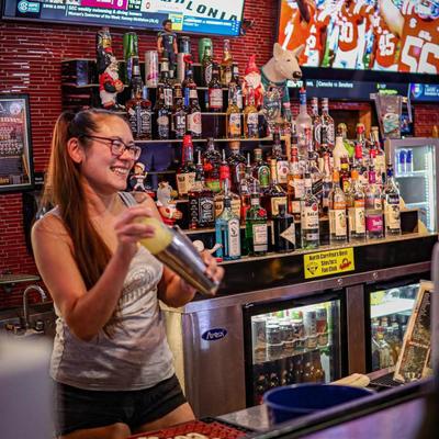 A person mixing a cocktail.