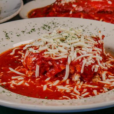 Lasagna in a rich tomato sauce topped with shredded mozzarella cheese.