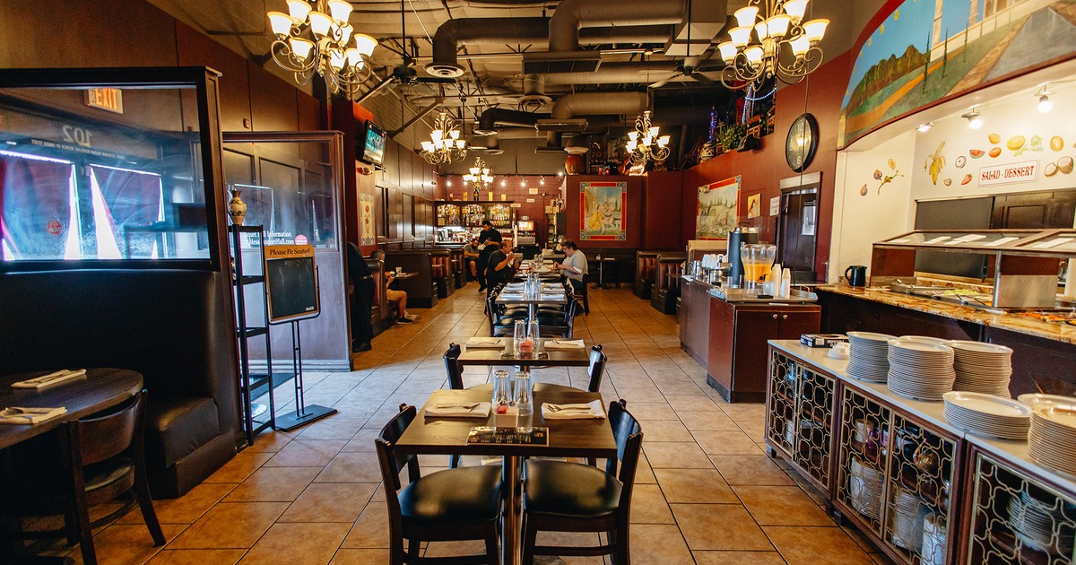 Restaurant interior, dining tables and booths, buffet with various food, entrance door