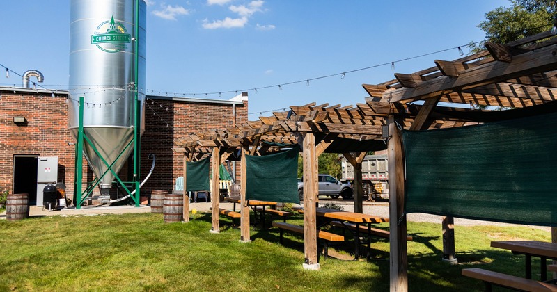 Exterior, terrace on the lawn in front of the brewery. benches and tables