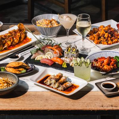 Diverse  dishes and several cocktails and wine glasses.