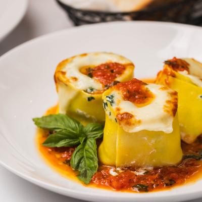 Rolled homemade pasta with spinach, ricotta, tomatoes, and basil.