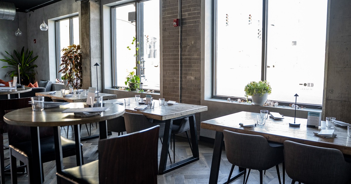 A modern and stylish restaurant interior dining area with tables set for guests