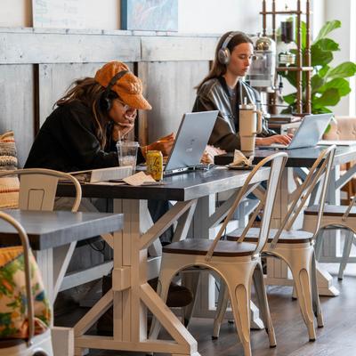 Two people working on laptops and having coffees.