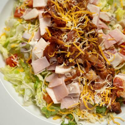 Club Salad with turkey, ham, onion, tomatoes, bacon, lettuce and cheddar.