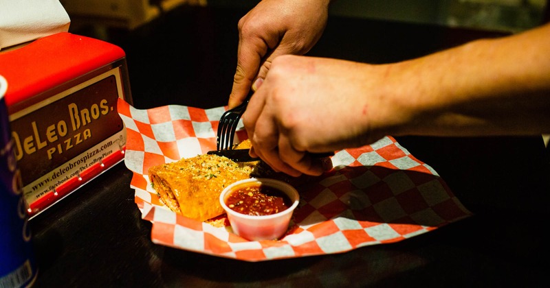 Hands cutting a stromboli