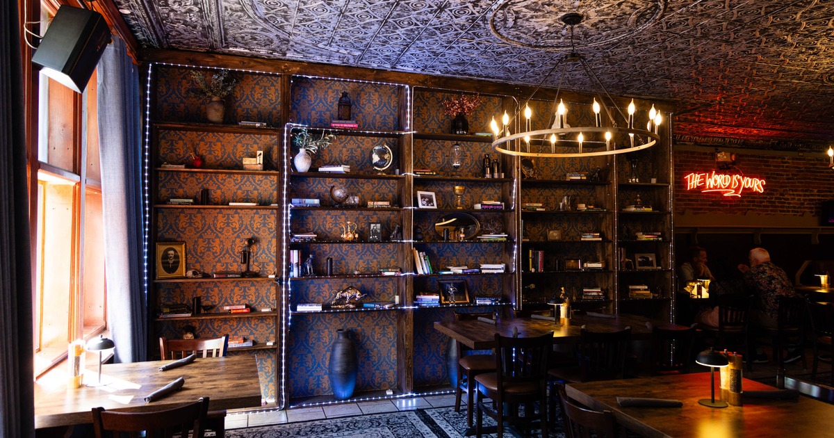Shelves with books, small sculptures, and framed pictures