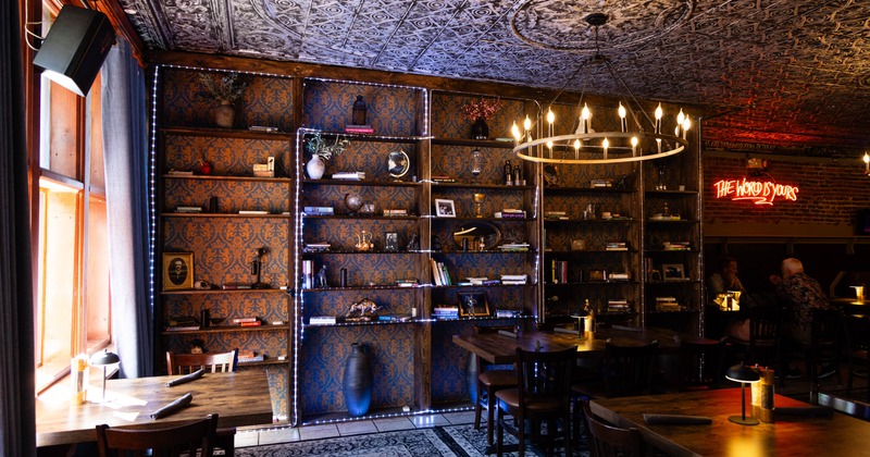 Shelves with books, small sculptures, and framed pictures