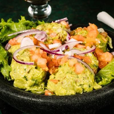 Guacamole, pico de gallo and onions dip closeup