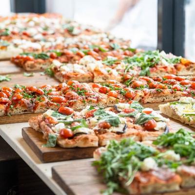 Assorted of square pizzas on a table.