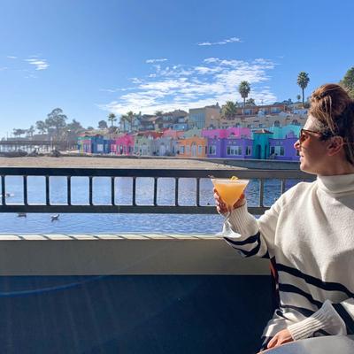 A person enjoying a drink in the sunlight.