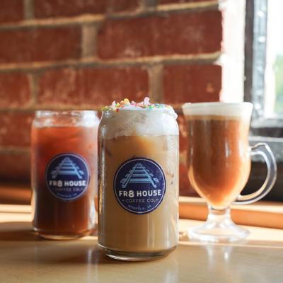 Three iced and hot coffee drinks sit on a table.