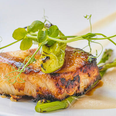 Grilled fish, dip, green decorations on top, closeup