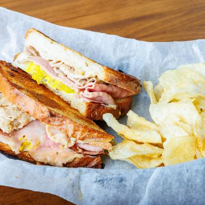 Rueben Sandwich served with chips on the side.