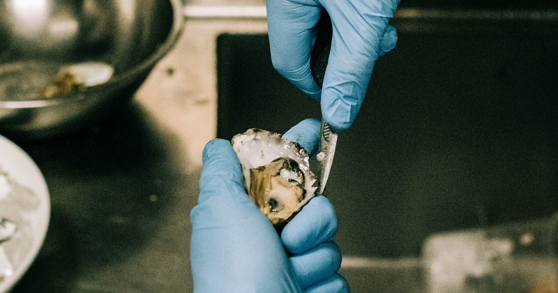 A chef preparing oysters to make a dish