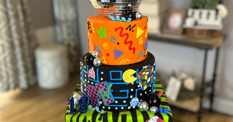 90's-themed cake with colorful decorations and a disco ball