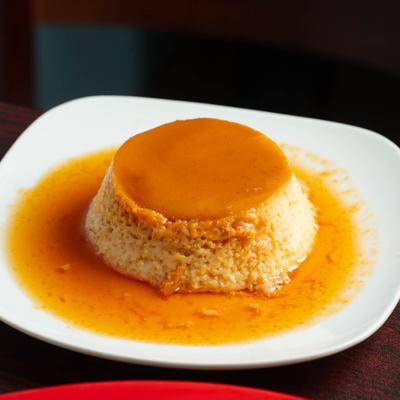 Flan dessert with caramel sauce on a white plate.
