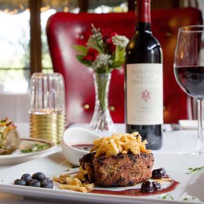 Steak with sauce, dips, blackberries and a glass of wine.
