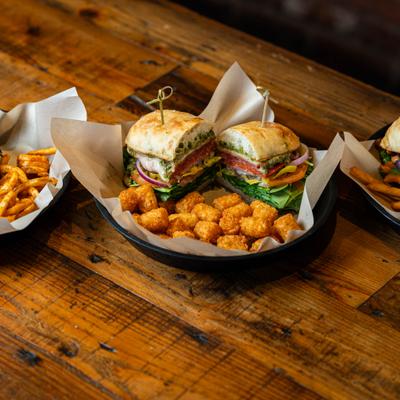 Hot Italian Sandwich with tater tots, served alongside other food.