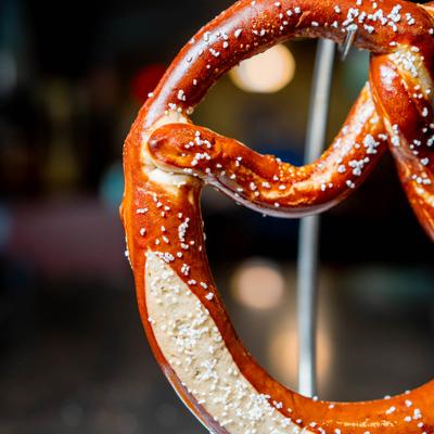 Close-up of a salted soft pretzel on a metal stand.