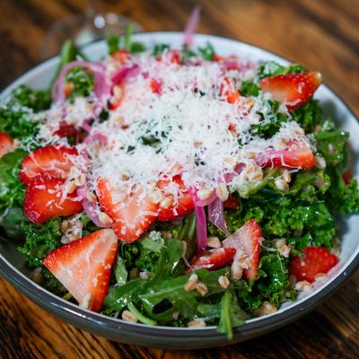 Mixed greens salad with strawberries, red onion, pistachio, and Parmesan.