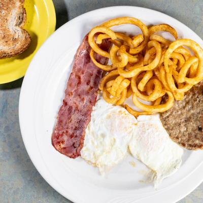Egg Platter with sausage patty, bacon and curly fries.