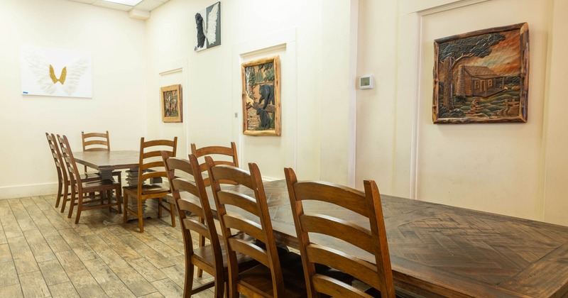 Interior, long dining tables and chairs, framed pictures on the wall