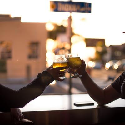 couple tapping glasses together at sunset.