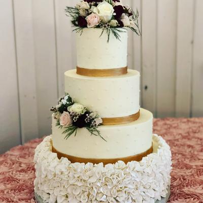Four tier white cake with rose ruffle base and smooth tiers, floral decoration