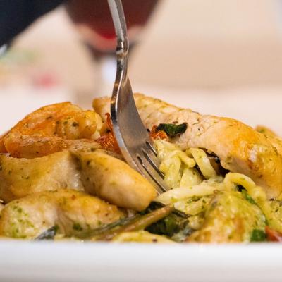 A fork in a plate of chicken pasta,.