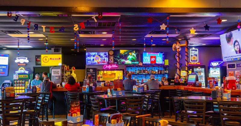 Interior, bar tables and stools, TV's screens on wall