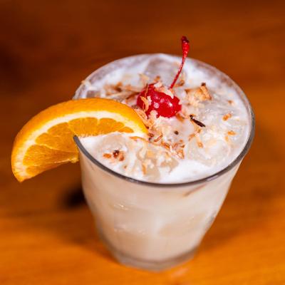 Lunar Coolatta cocktail , garnished with orange wedge and cherry.