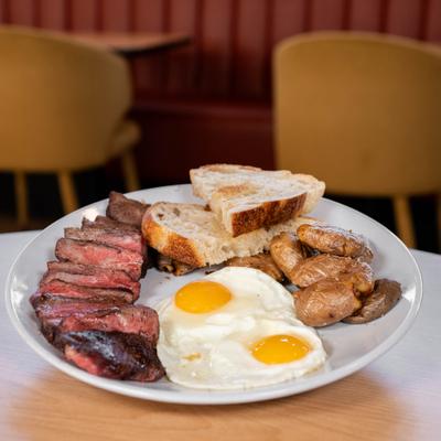 American breakfast with steak and eggs.