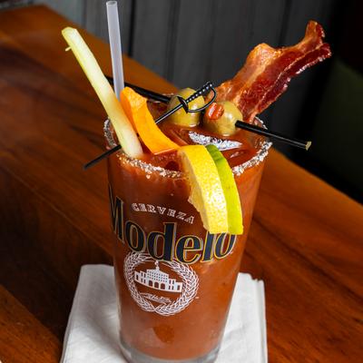 Bloody Mary garnished with bacon, celery, olives, and citrus.