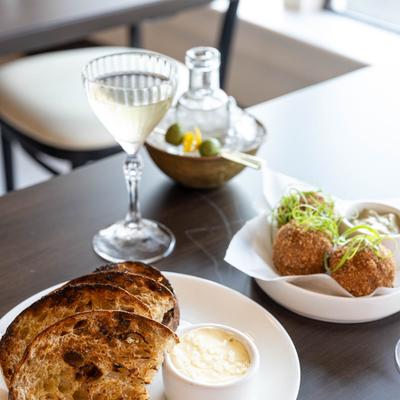 Toasted sourdough, fried balls, and a glass of wine.