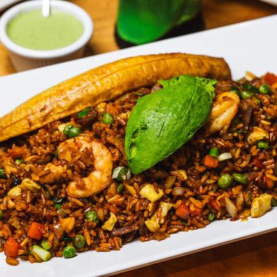 Stir fried rice with chicken, beef, shrimp, egg, veggies, plantain, and avocado.